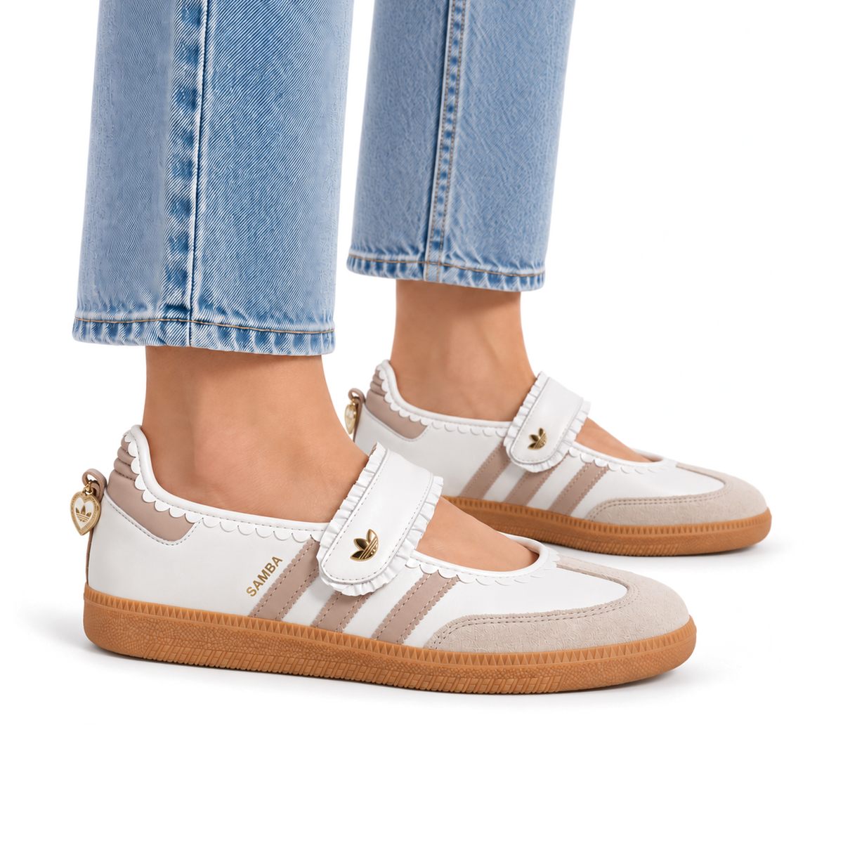 Woman wearing white and pink adidas Samba Jane Ruffle shoes with cropped blue jeans, showing the Mary Jane straps and gum soles.
