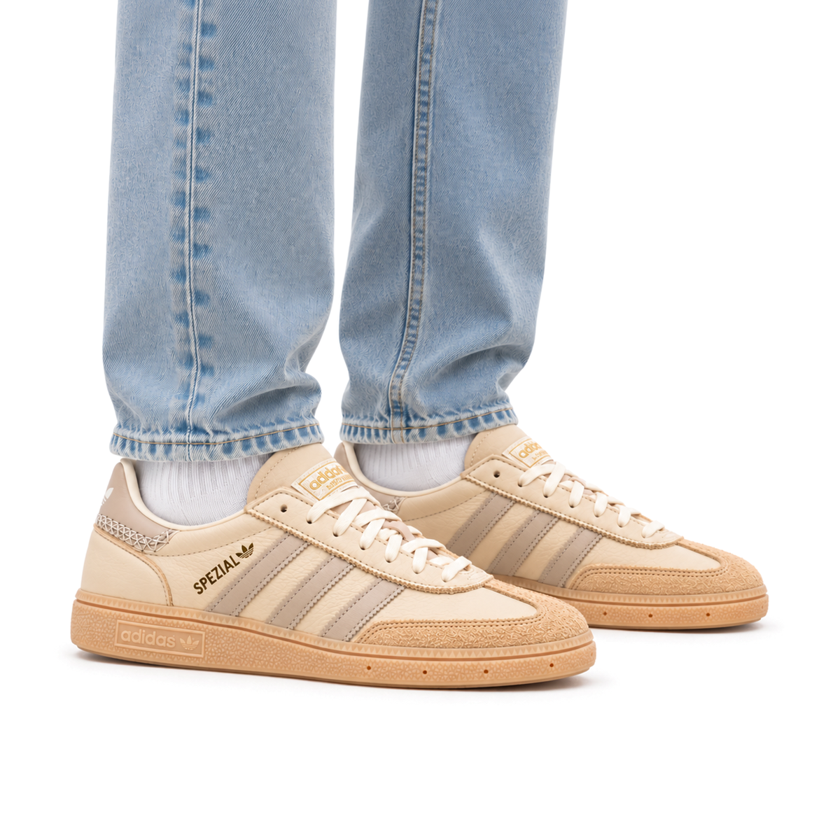 Adult wearing right-facing adidas Handball Spezial Cream White Beige shoes with light wash jeans and white socks