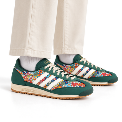 Green floral adidas x Liberty London SL 72 OG sneakers styled with ivory trousers and white socks in an on-foot view.