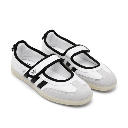 Front three-quarter view of the white and black Samba Jane Ruffle pair, showing black-edged Mary Jane straps and light grey T-toe panels.