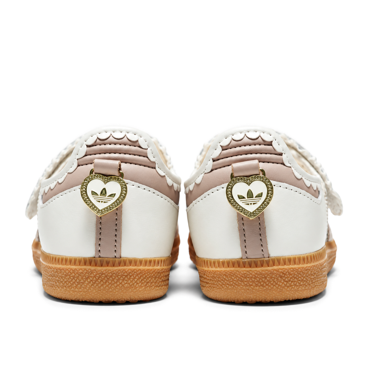 Rear view of white and pink Samba Jane Ruffle shoes with gold heart-shaped heel charms above the gum soles.