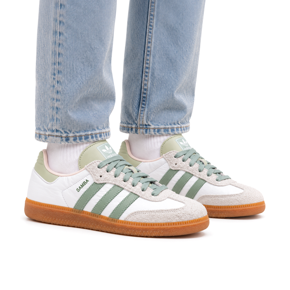 Adult wearing right-facing adidas Samba Silver Green shoes with light wash jeans and white socks
