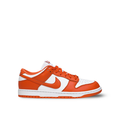 Low-top sneaker with a white leather base and vibrant orange overlays, including the Nike Swoosh logo. It features orange laces and a white midsole with an orange outsole.